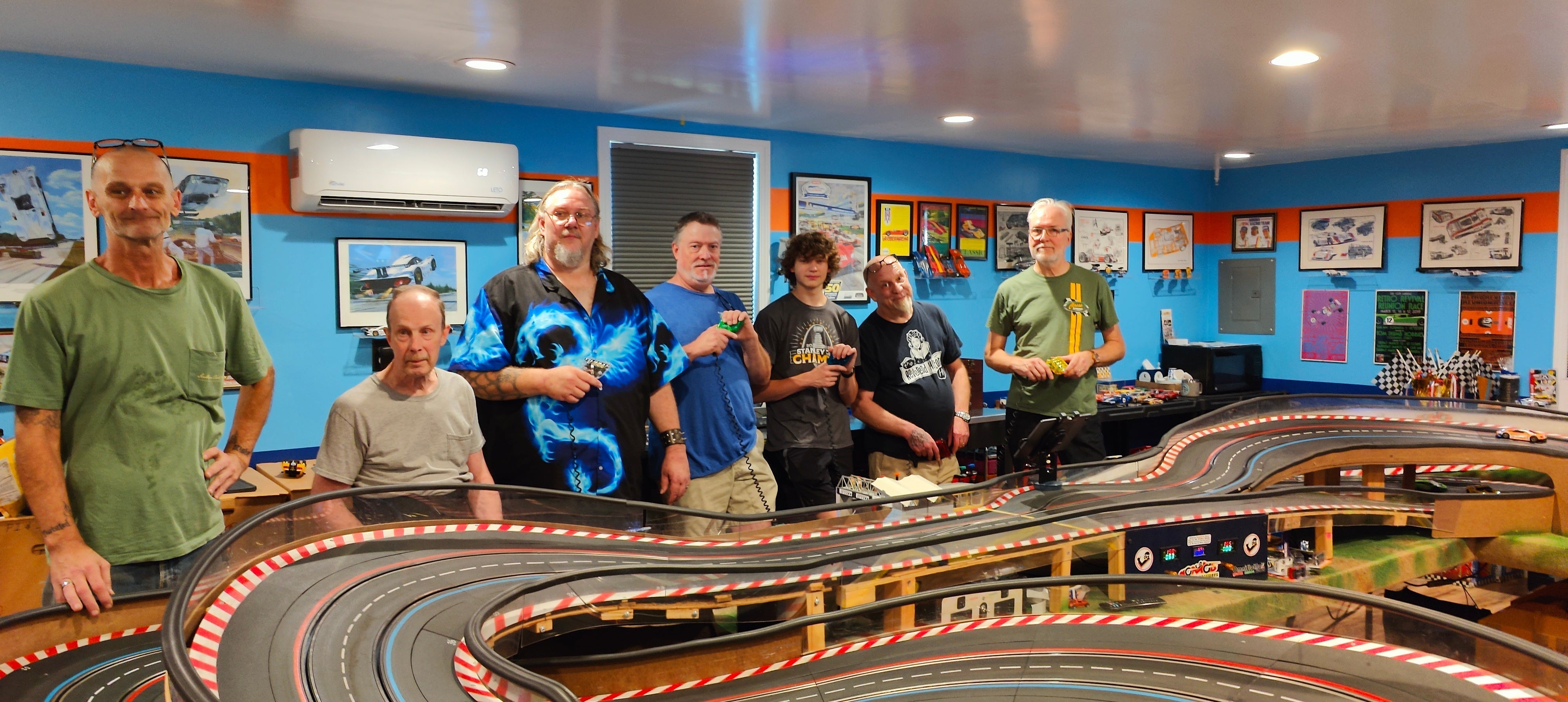 Wide photo of the Slot Car Clubhouse with racers and track.