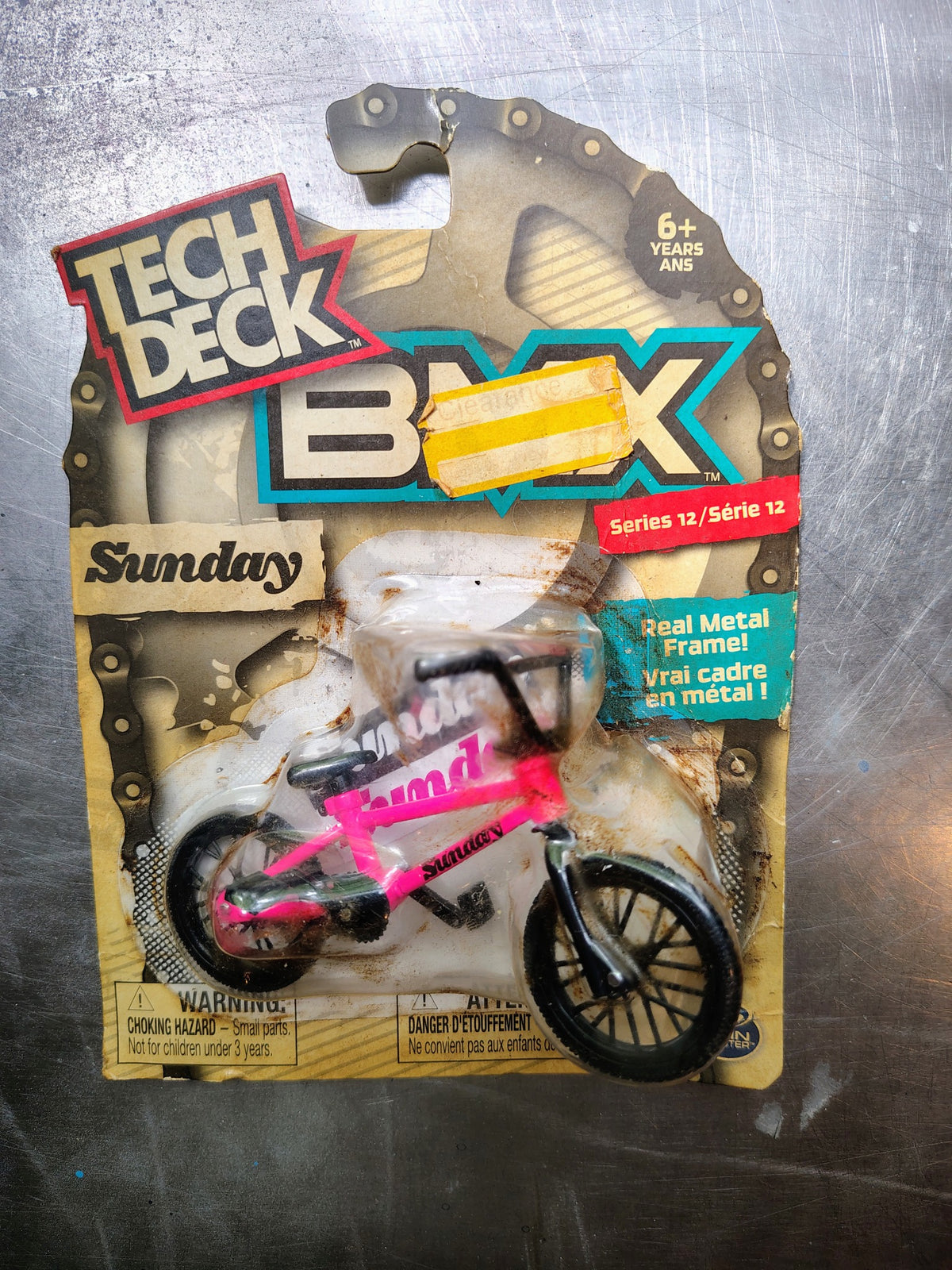 Actual included collectible 3: Tech Deck BMX Sunday miniature bicycle with pink metal frame, original blister card showing substantial discol
