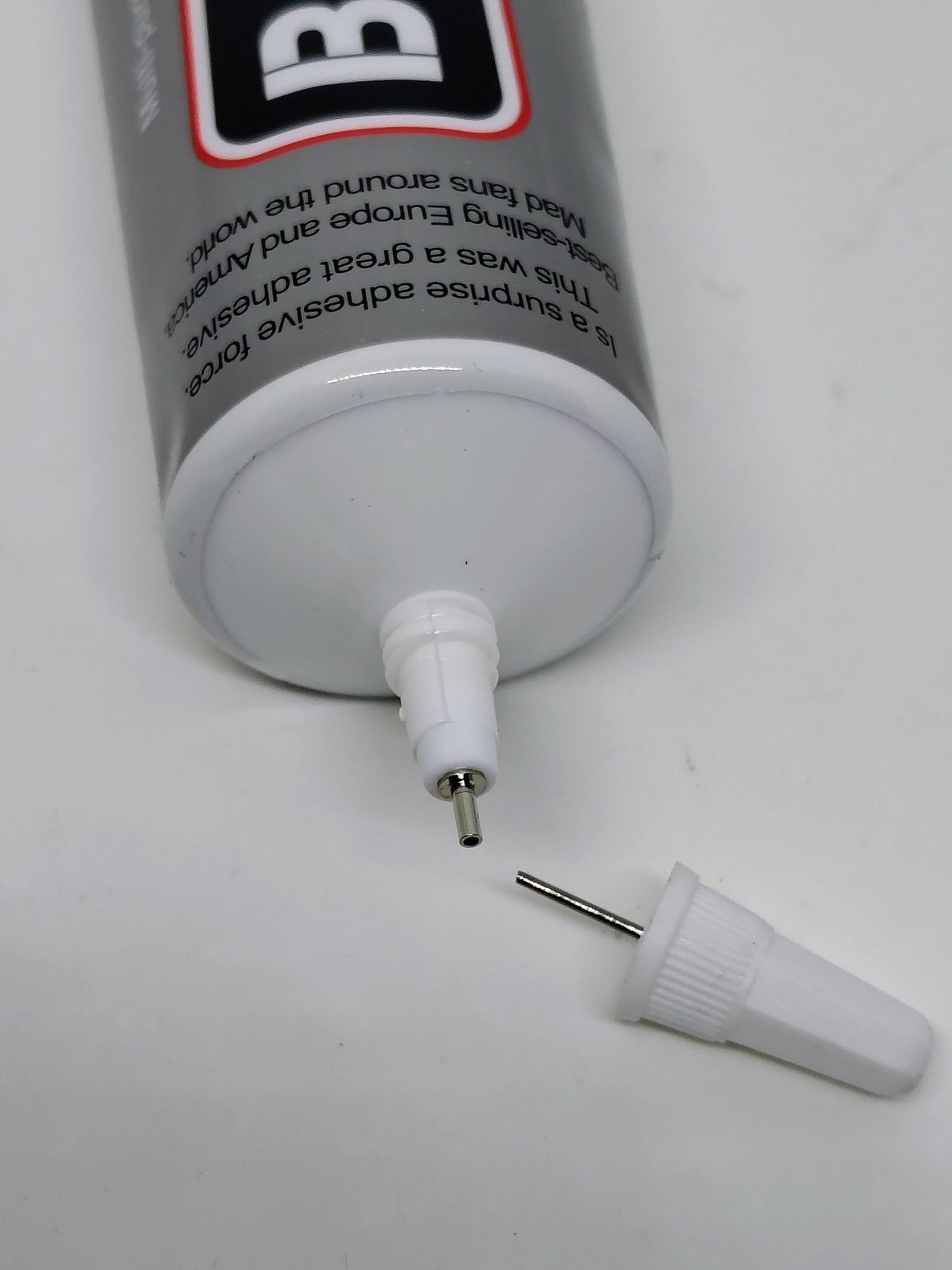 Close view of B-6000 fine metal glue nozzle and unclogging pin cap