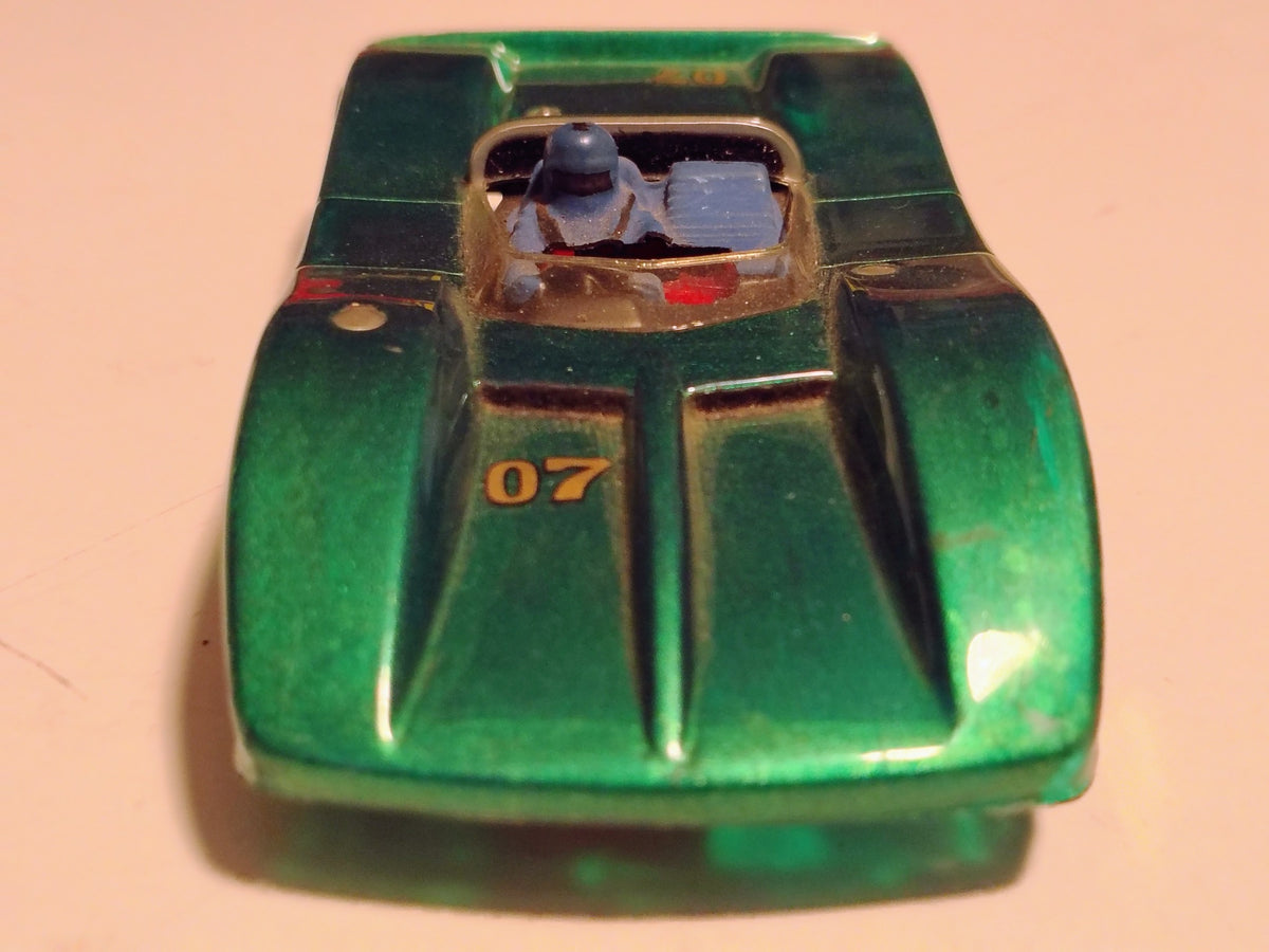 Green #07 vintage Can-Am racer front with cockpit and blue driver